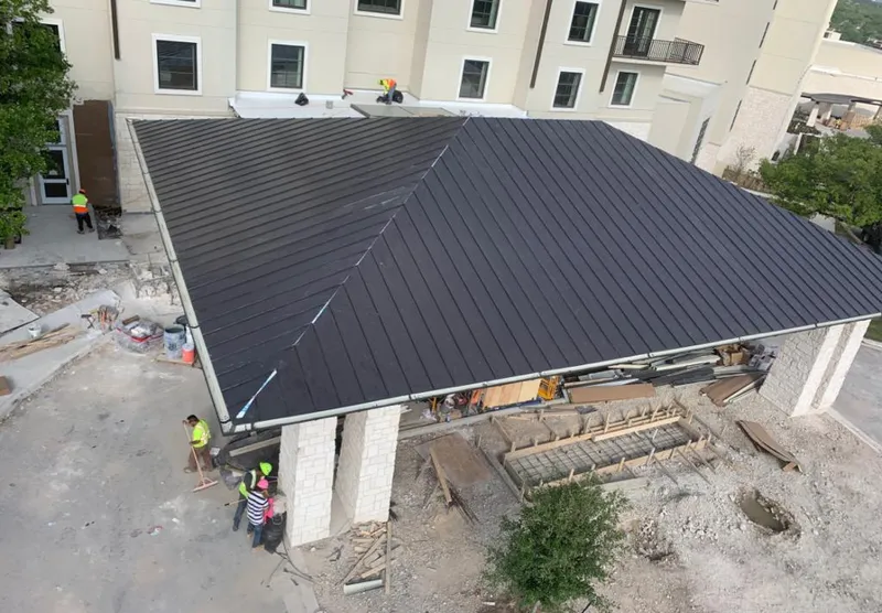 Metal roofing installation team working on a commercial building in Madera